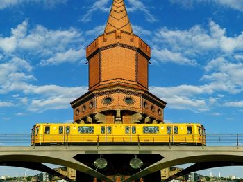 Low angle view of train on oberbaum bridge against sky in city
