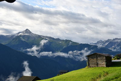 Scenic view of mountains and buildings against sky