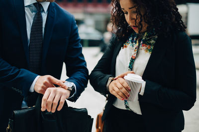 Business coworkers looking at time in wristwatches