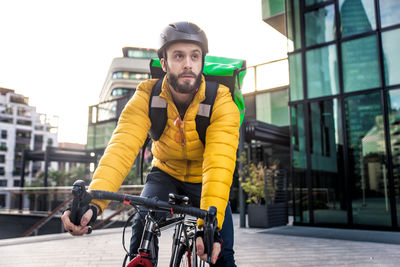 Young man riding bicycle on city street