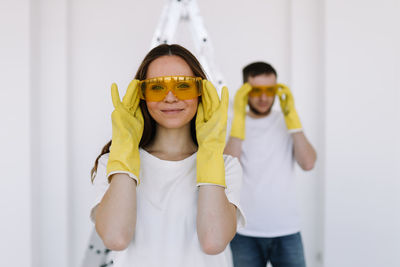 A young couple in love have moved into a new house and are making repairs painting white walls