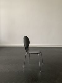 Empty chair on table against wall