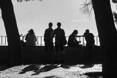 Silhouette people at observation point against sky