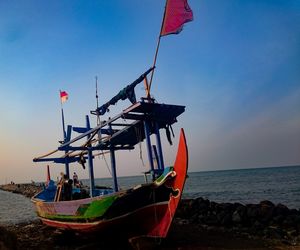 Low angle view of flags on beach against sky