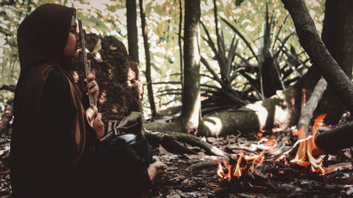 Rear view of woman relaxing in forest