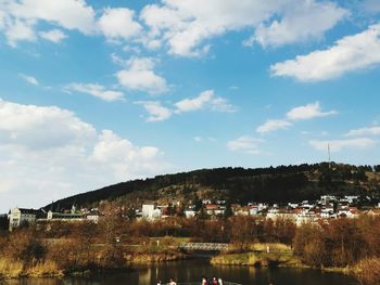 Buildings by lake against sky