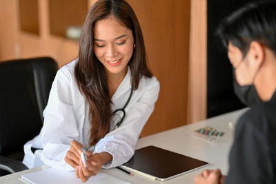 Young woman using smart phone on table