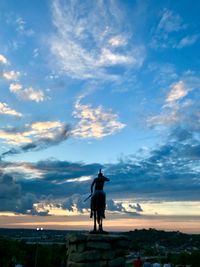 Silhouette statue against sky during sunset