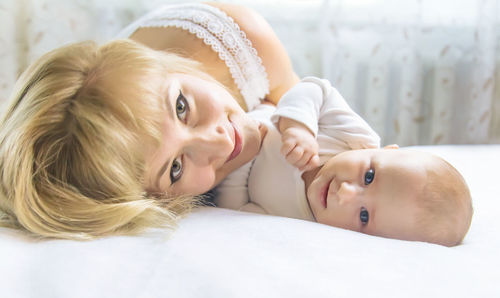 Mother with daughter lying on bed at home