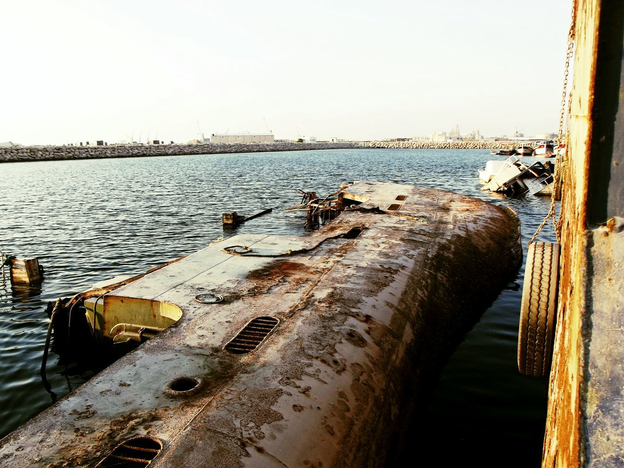 water, sea, nautical vessel, clear sky, built structure, transportation, architecture, rusty, boat, mode of transport, moored, river, harbor, pier, sky, building exterior, old, day, metal, connection