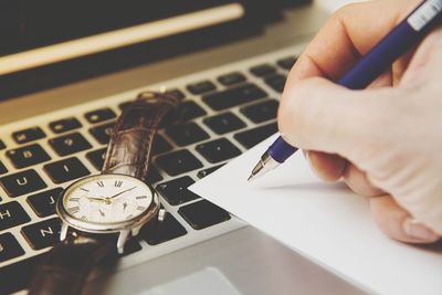 Close-up of person using laptop on table