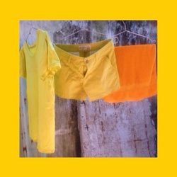Close-up of clothes drying against yellow background