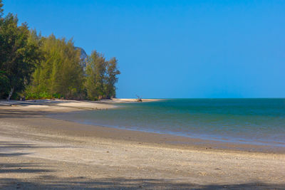 Scenic view of beach against clear blue sky