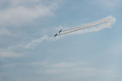 Low angle view of airshow against sky