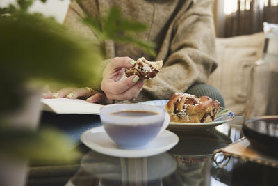 Woman reading book and having tea and snack