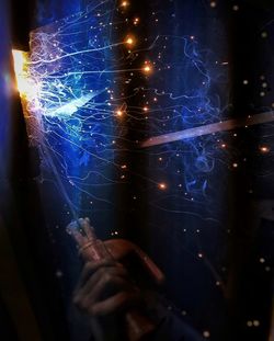 Close-up of hand holding illuminated light painting at night