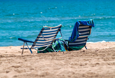 Summer vacation on the beach with beach chairs and towels in front of the sea