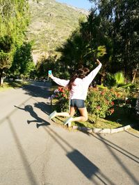 Low section of woman jumping on tree