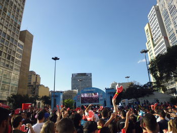 Crowd in city against clear sky