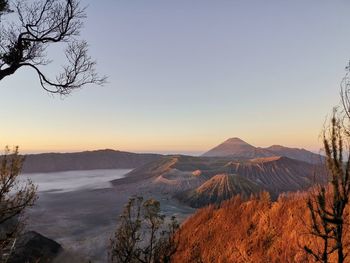 Scenic view of volcanic landscape against clear sky during sunset