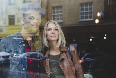 Thoughtful couple in coffee shop seen through window