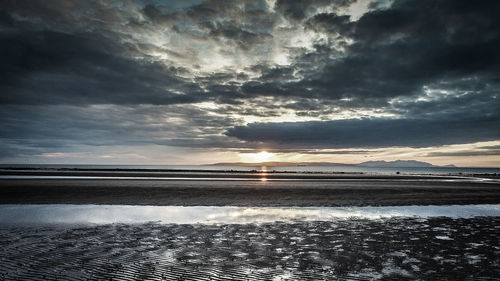 Scenic view of beach against sky during sunset