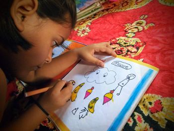 Close-up of girl coloring on book at home