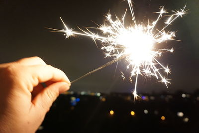 Close-up of hand holding sparkler at night