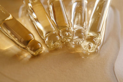 Pipettes with oil or serum on a golden background.