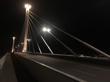 Illuminated bridge against sky at night