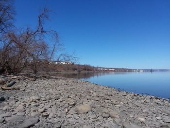 Scenic view of lake against clear blue sky