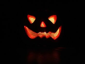 Close-up of illuminated pumpkin against black background