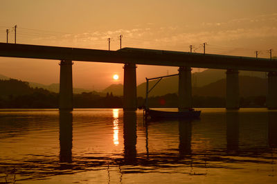 Bridge over sea against sky during sunset