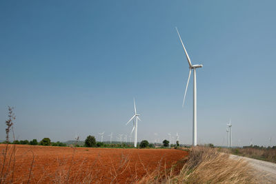 Windmill on field against clear sky