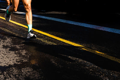 Low section of man running on road