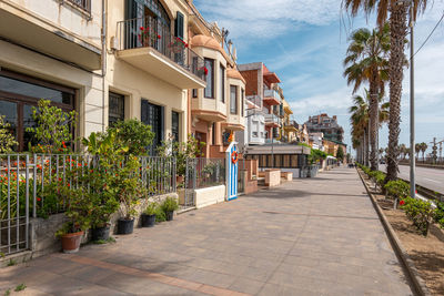 Footpath amidst buildings against sky