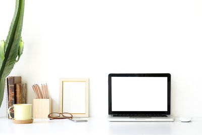 Close-up of laptop on table against white background