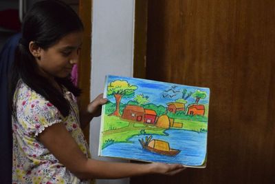 Close-up of girl holding camera at home