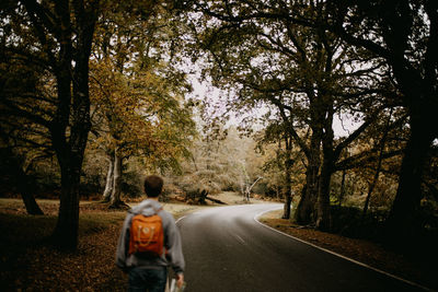 Rear view of woman walking on road