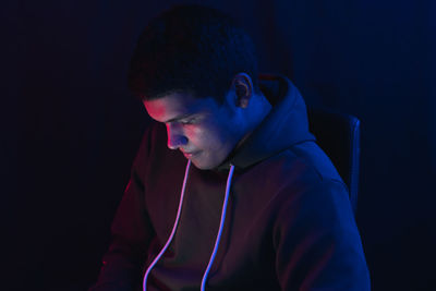 Portrait of young man against black background