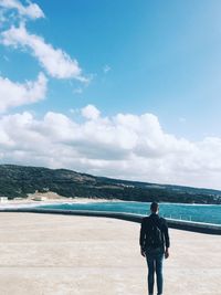 Rear view of man standing on promenade against sky