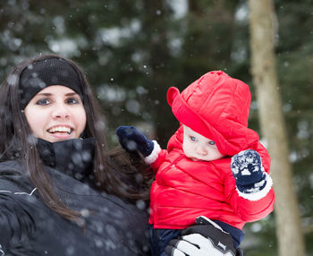 Portrait of mother and daughter in snow during winter