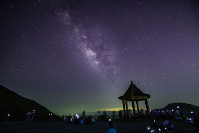 Low angle view of illuminated buildings against sky at night