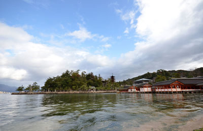 Itsukushima shrine by sea against sky