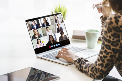 Midsection of woman using laptop on table