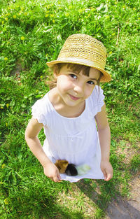 High angle view of young woman sitting on grassy field