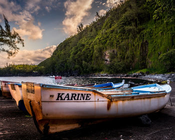 Boats moored on beach against sky