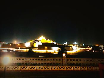 Illuminated buildings against sky at night