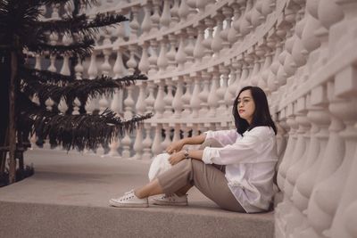 Portrait of young woman sitting on street