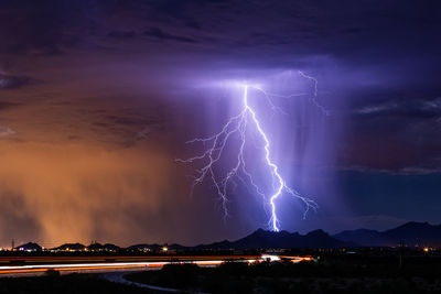 Lightning over illuminated city at night